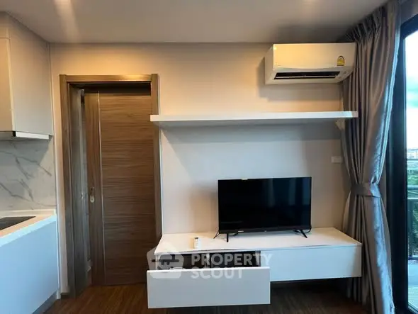 Modern living room with TV, air conditioning, and sleek design elements.