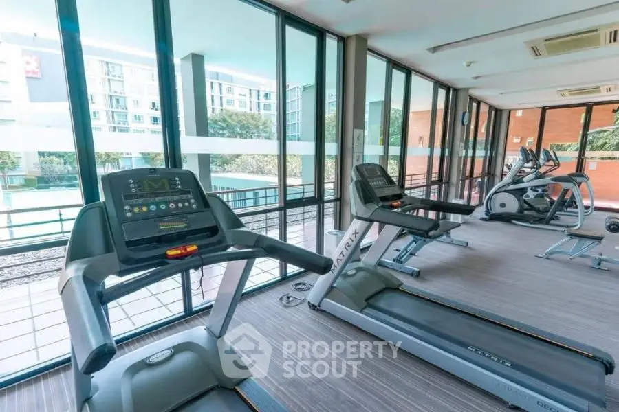 Modern gym with state-of-the-art equipment and large windows offering a scenic view.