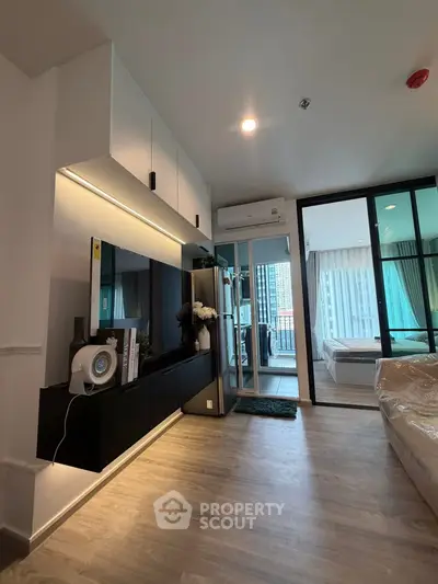 Modern apartment interior with sleek design and spacious layout, featuring a view into the bedroom and balcony.
