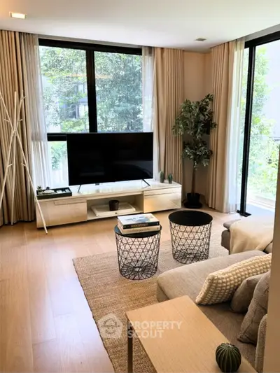 Modern living room with large windows, stylish furniture, and natural light.