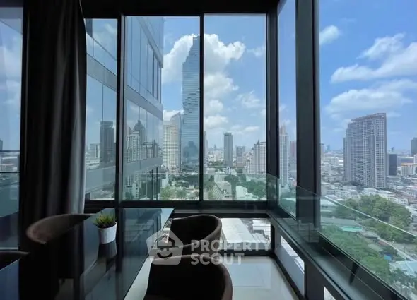 Stunning city view from modern high-rise apartment with floor-to-ceiling windows.