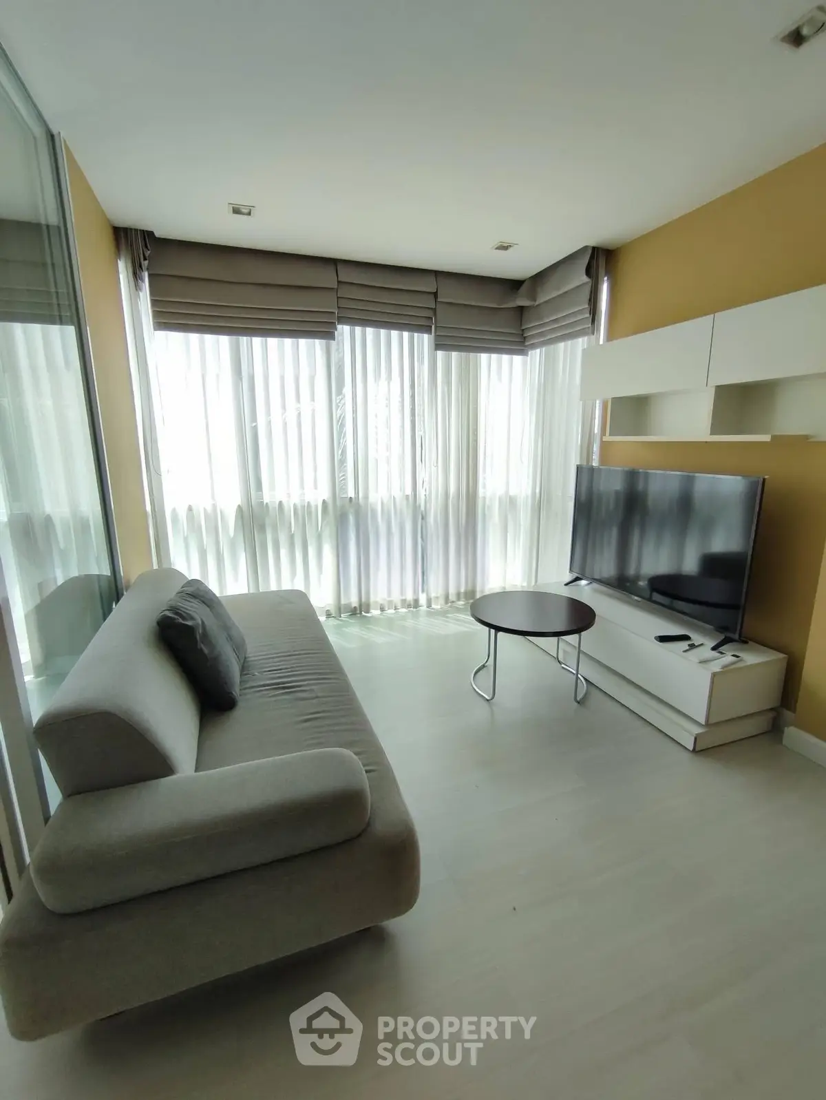 Modern living room with large windows and sleek furniture in a stylish apartment.