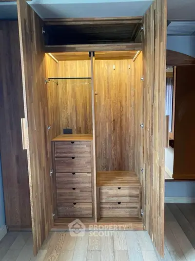 Spacious wooden walk-in closet with ample storage and elegant design