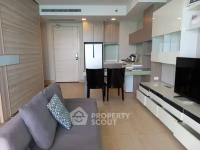 Modern living room with sleek furniture and open kitchen layout in a stylish apartment.