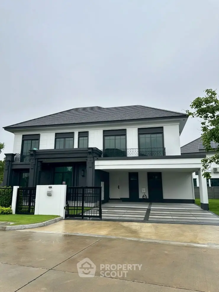 Modern two-story house with sleek design and spacious driveway, perfect for contemporary living.