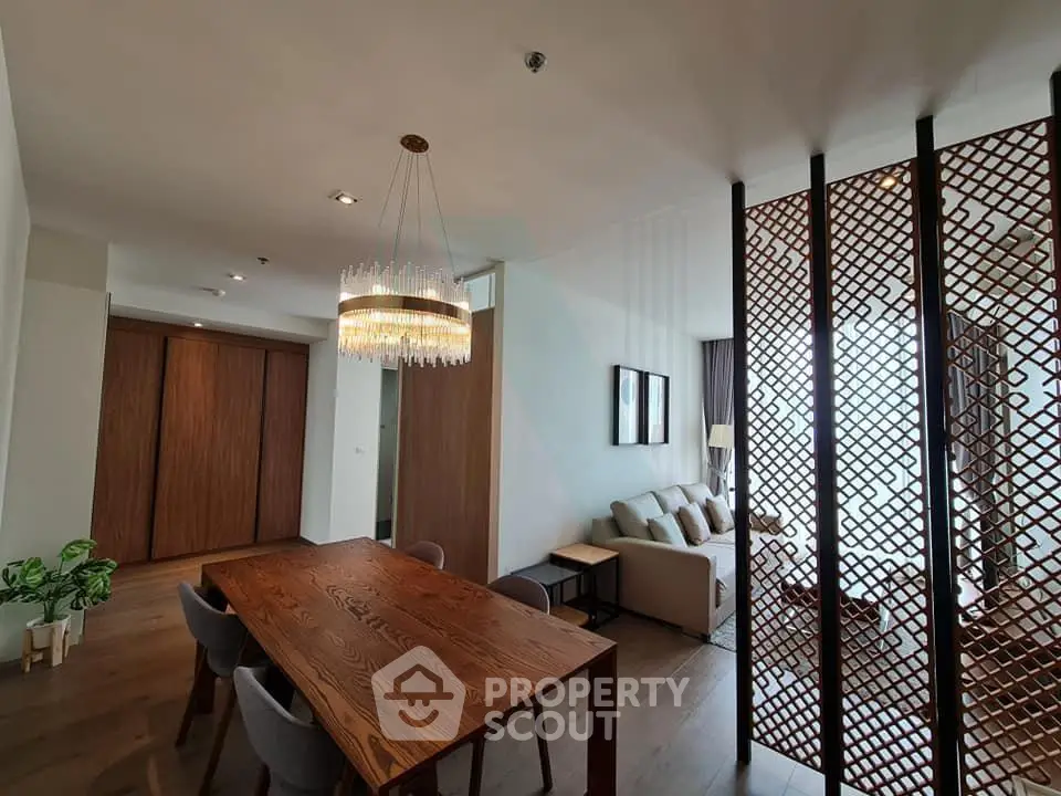 Elegant open-plan living and dining area with modern decor and stylish lighting