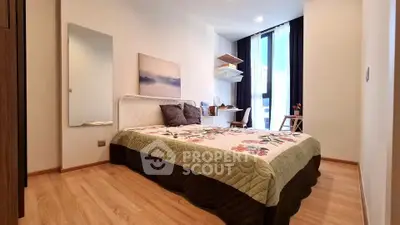 Cozy bedroom with modern decor and natural light, featuring a stylish workspace and elegant wooden flooring.