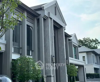 Elegant modern townhouse exterior with lush greenery and stylish architectural design.