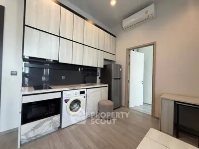 Modern kitchen with sleek cabinetry, built-in appliances, and stylish flooring in a contemporary apartment.