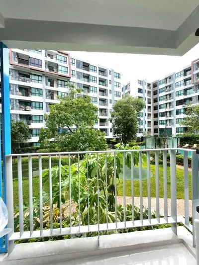 Spacious balcony with lush garden view in modern apartment complex