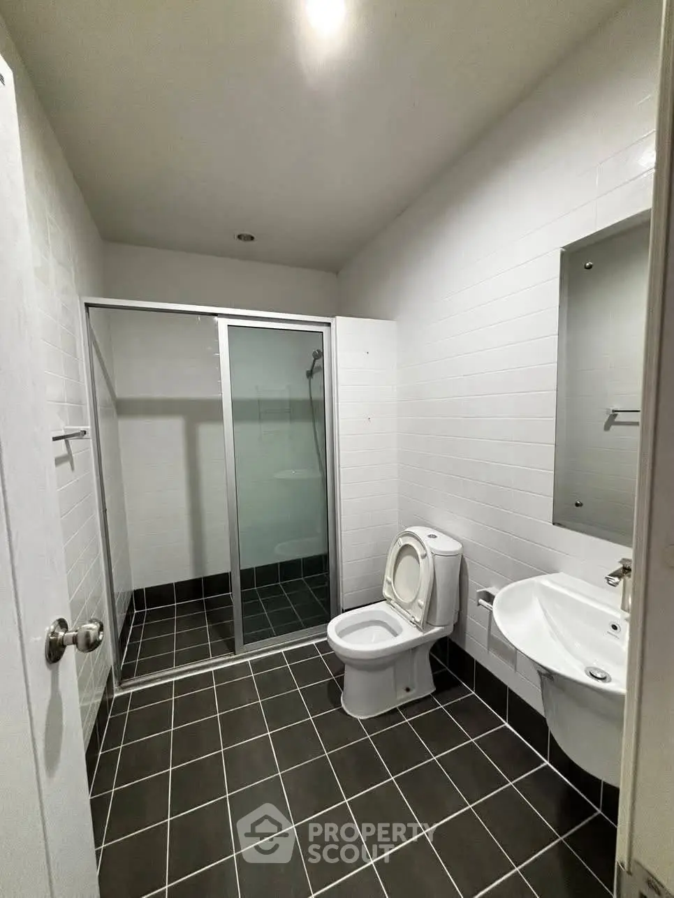 Modern bathroom with sleek design, featuring a glass shower enclosure and stylish fixtures.