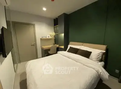 Modern bedroom with a plush queen-sized bed, elegant dark green accent wall, and sleek built-in shelving, offering a cozy and stylish living space.