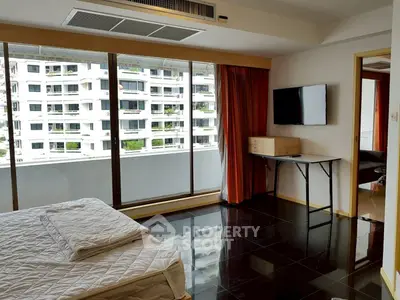 Spacious bedroom with balcony view in modern apartment