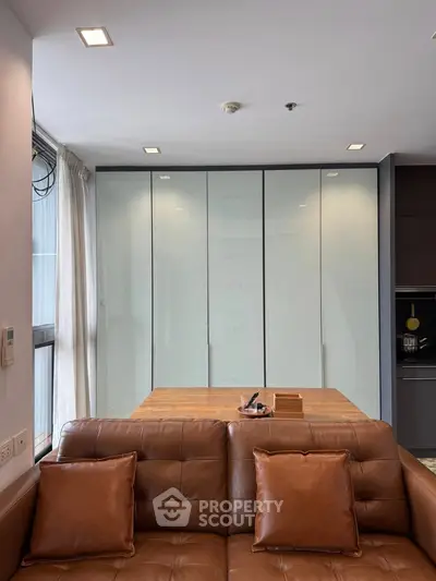 Modern living room with sleek leather sofa and stylish cabinetry