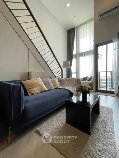 Modern living room with high ceiling and stylish decor in a luxury apartment.