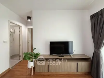 Modern living room with TV and wooden cabinet, bright and airy space.