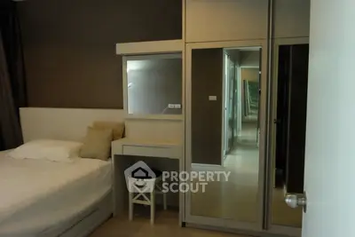 Cozy bedroom with mirrored wardrobe and vanity desk, perfect for modern living.