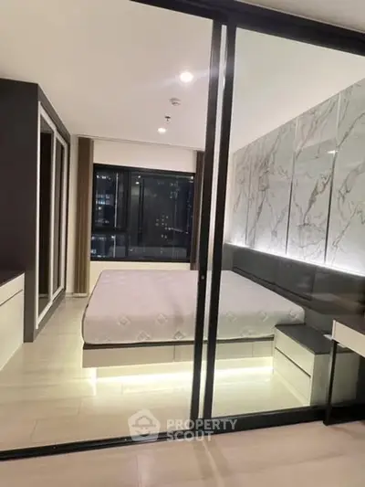 Luxurious modern bedroom with glass partition and elegant marble accent wall.