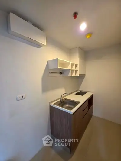 Modern compact kitchen with sleek cabinetry and built-in electric stove