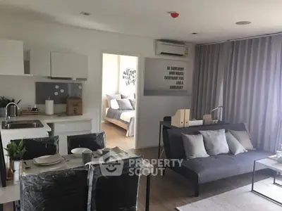 Modern open-plan living room with dining area and bedroom view