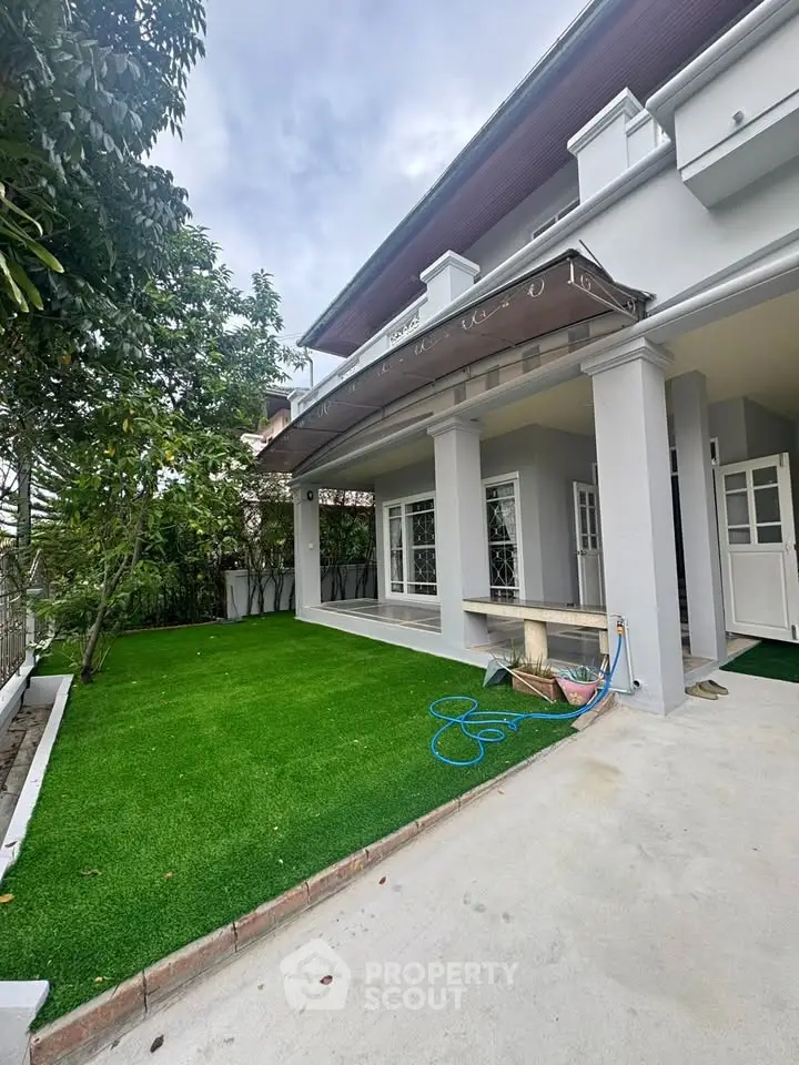 Charming house with lush garden and spacious patio, perfect for outdoor relaxation.