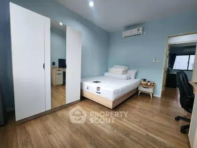 Spacious bedroom with modern furnishings and wooden flooring