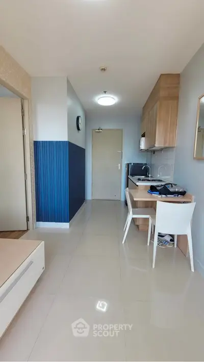 Modern compact kitchen with sleek design and dining area in a stylish apartment.