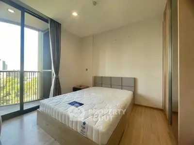 Spacious bedroom with balcony view in modern apartment