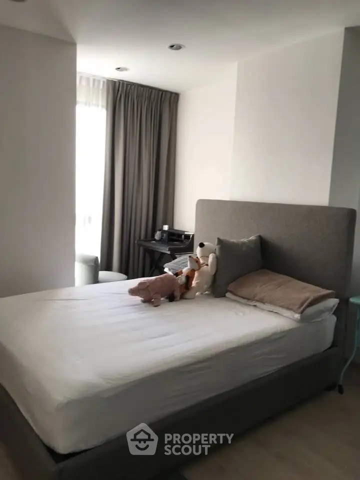 Cozy bedroom with plush bed and natural light, perfect for relaxation.