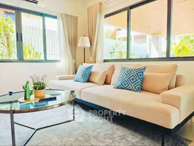 Stylish living room with modern sofa and large windows offering natural light