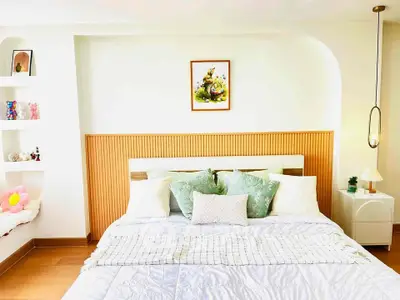 Cozy bedroom with stylish decor and plush bedding in modern apartment.