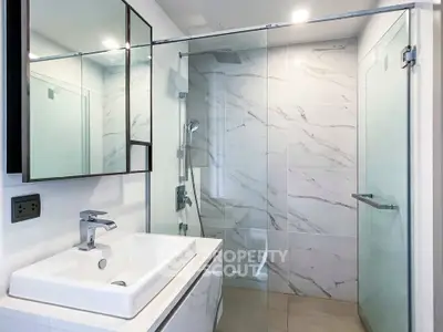 Modern bathroom with sleek glass shower and elegant marble tiles