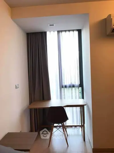 Cozy study nook with natural light and modern chair in a stylish apartment.
