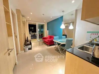Modern living room with vibrant decor and open kitchen layout in a stylish apartment.