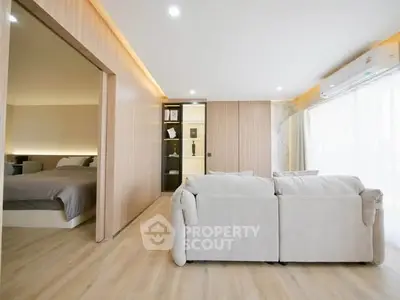 Spacious modern living room with open layout and cozy bedroom view