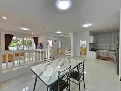 Spacious open-plan living and dining area with modern kitchen and elegant marble table.