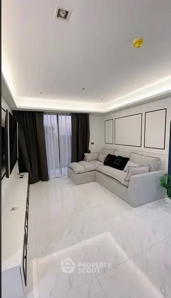 Modern living room with sleek design, featuring a cozy sectional sofa and elegant lighting.