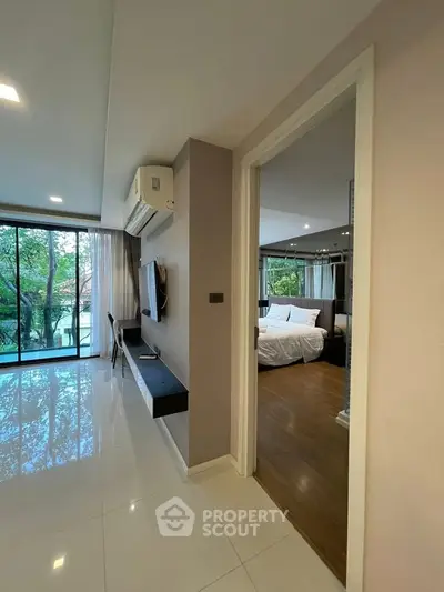 Modern apartment interior with spacious living area and bedroom, featuring large windows and stylish decor.
