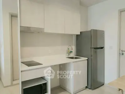 Modern minimalist kitchen with sleek cabinetry and stainless steel fridge
