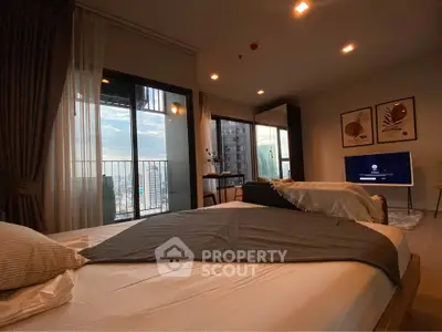 Spacious bedroom with balcony and city view, modern decor and natural light.