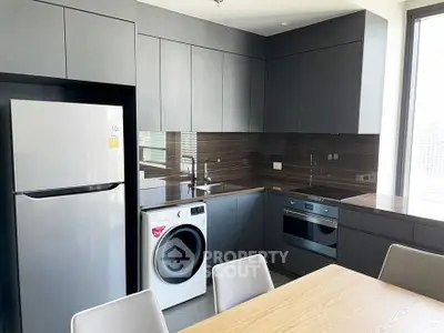 Modern kitchen with sleek cabinetry, stainless steel appliances, and integrated washer in a stylish apartment.