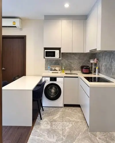 Modern kitchen with sleek cabinetry, integrated appliances, and stylish marble flooring.