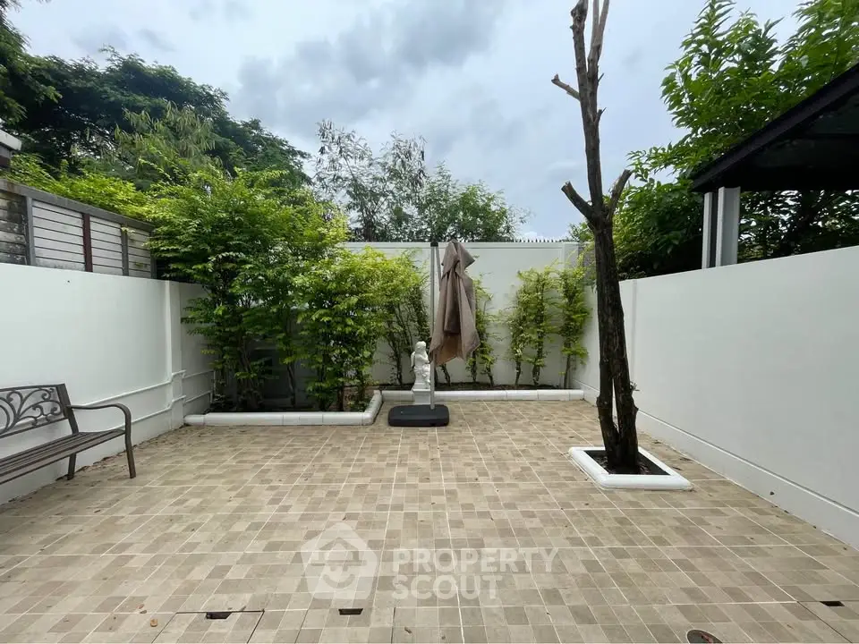 Charming private garden with tiled patio and lush greenery