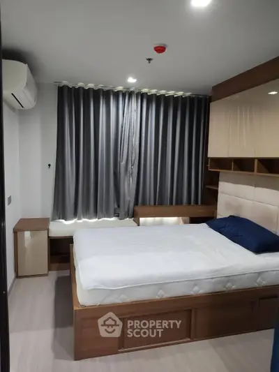 Modern bedroom with stylish furnishings and ample natural light, featuring a cozy bed and elegant curtains.