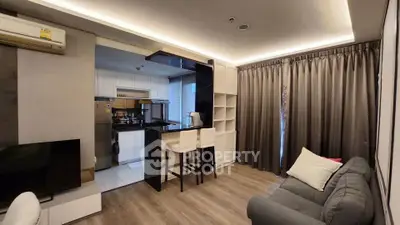 Modern open-layout living room with sleek kitchen and cozy seating area, perfect for urban living.