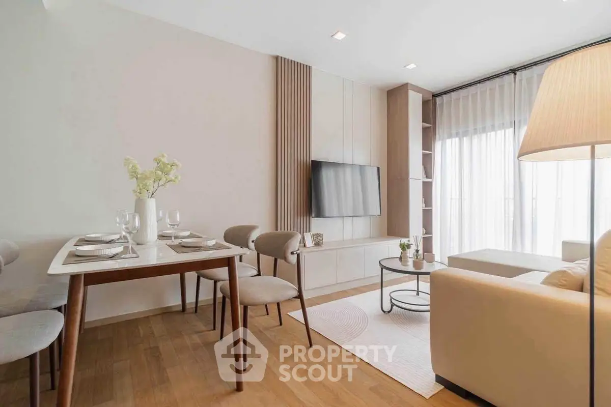Modern living room with elegant dining area and cozy seating, featuring stylish decor and natural light.