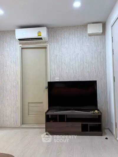 Modern living room with sleek TV setup and air conditioning unit