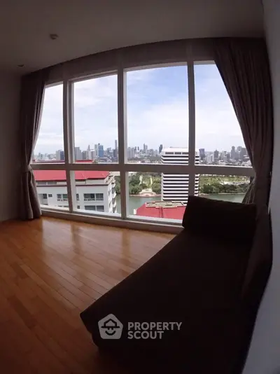 Spacious room with stunning city skyline view through large windows.