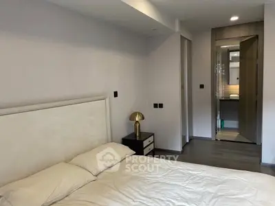 Modern bedroom with stylish decor and ensuite bathroom in luxury apartment.