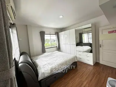 Spacious bedroom with modern furnishings and large windows for natural light.